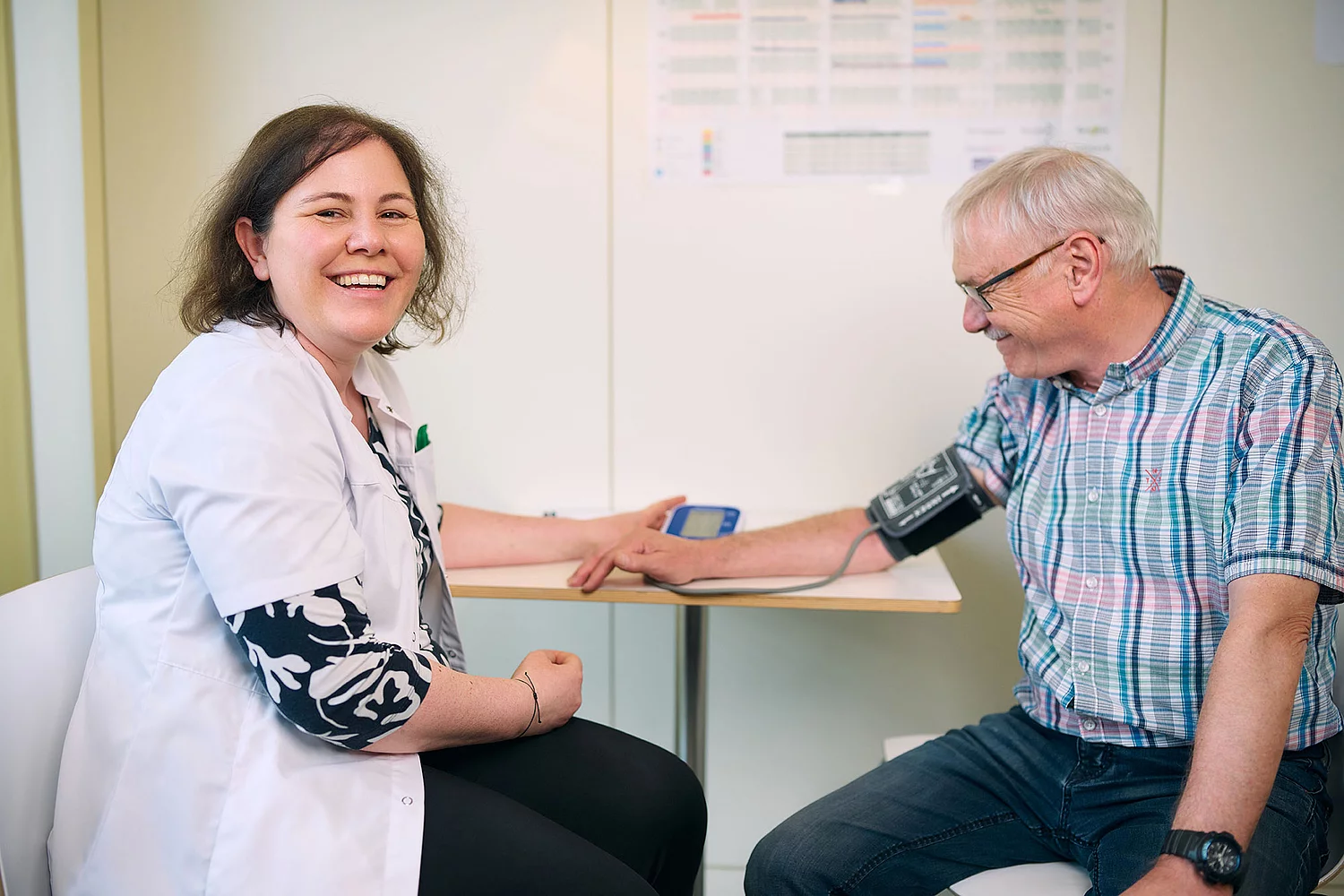 freundliche Apothekerin misst Patienten Blutdruck